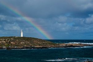 photo of rainbow over lighthouse