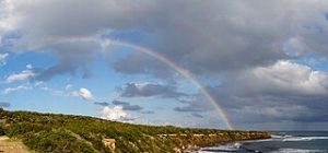 photo of rainbow with clouds in background