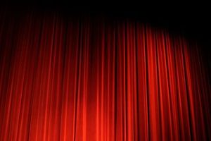 Image of red curtain drawn across a stage